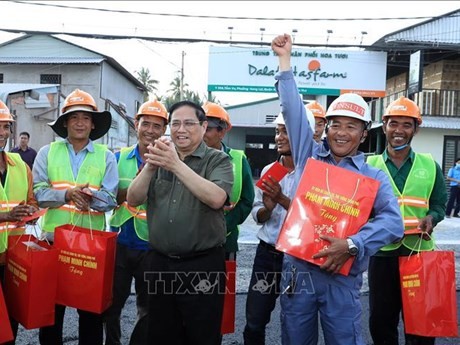 El primer ministro de Vietnam, Pham Minh Chinh, entrega regalos a trabajadores que están construyendo un dique del río Can Tho (Foto: VNA)