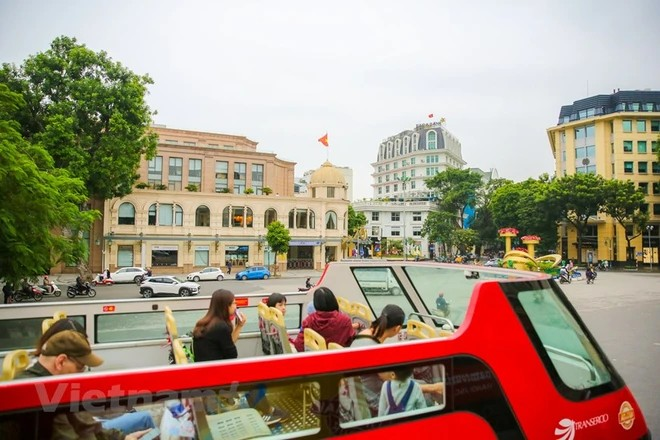 Turistas realizan un recorrido por Hanói en autobus de dos pisos. (Fuente: VNA)