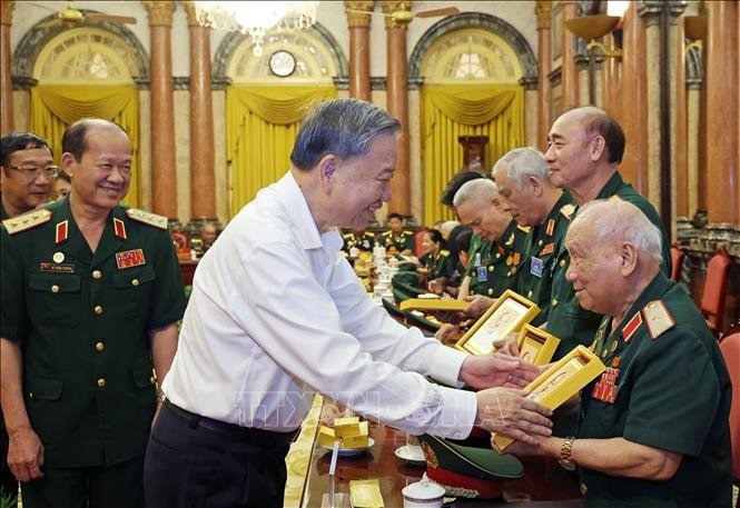 El presidente To Lam entrega una fotografía del Presidente Ho Chi Minh al mayor general Vo So, de 96 años, jefe del Comité de Enlace de Veteranos de la División 305 de Caballería Aérea y Fuerzas Especiales. (Fuente: VNA)