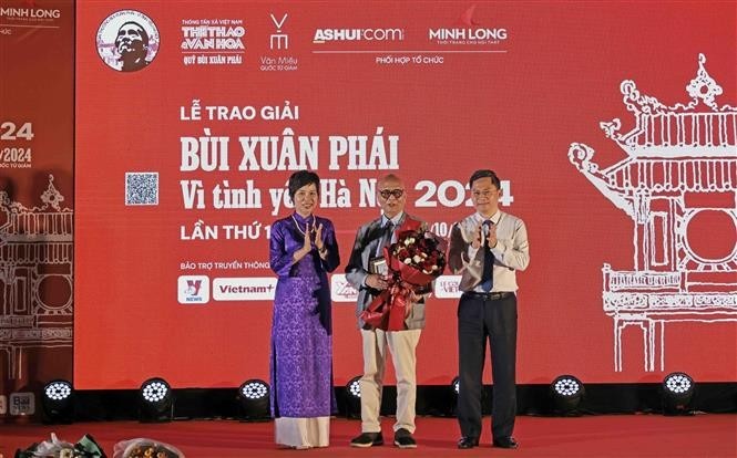 La directora general de la Agencia Vietnamita de Noticias, Vu Viet Trang, entrega el Gran Premio al arquitecto Hoang Dao Kinh. (Foto: VNA)