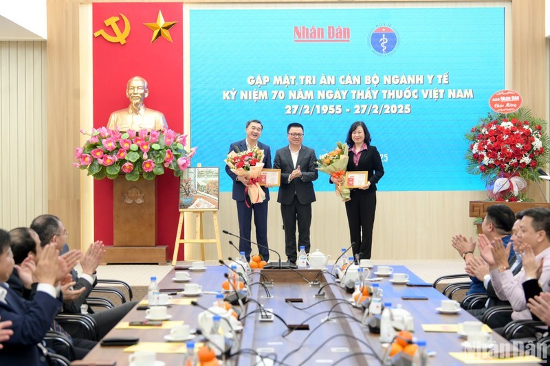 El compañero Le Quoc Minh entrega la placa conmemorativa “Por la carrera del Periódico Nhan Dan” a la ministra de Salud Pública, Dao Hong Lan, y al viceministro de la cartera Tran Van Thuan. (Fotografía: The Dai)