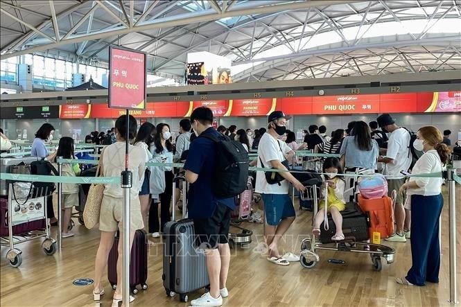 Turistas hacen cola para facturar vuelos a la isla vietnamita de Phu Quoc en el Aeropuerto Internacional de Incheon, en Corea del Sur. (Fotografía: VNA)