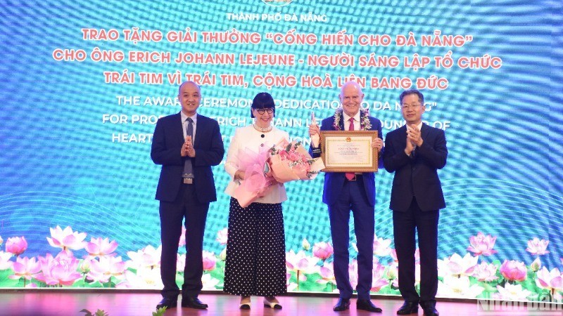 El secretario del Comité del Partido Comunista en Da Nang, Nguyen Van Quang, otorga el premio “Dedicación a Da Nang” al profesor Erich Johann Lejeune. (Fotografía: Anh Dao)