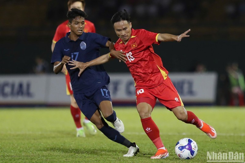 Un jugador vietnamita (con camiseta roja) disputa por el balón. (Fotografía: Nhan Dan)