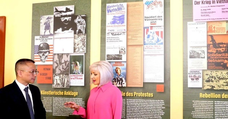 Claudia Opitz, uno de los organizadores de la exposición, presenta con el ministro consejero Chu Tuan Duc de la Embajada de Vietnam en Alemania sobre la exhibición de fotos y pinturas. (Fotografía: VNA)