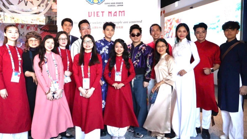 Los artistas vietnamitas se toman fotos en el pabellón de su país en la EXPO 2025. (Fotografía: Nhan Dan)