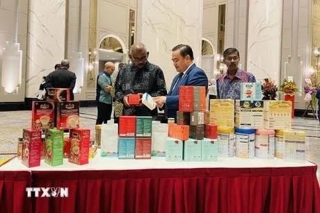 El consejero comercial vietnamita en Malasia, Le Phu Cuong (centro), presenta productos tradicionales vietnamitas al público. (Fotografía: VNA)