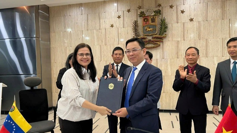 El vicepresidente de la Unión de Organizaciones de Amistad de Vietnam Dong Huy Cuong y la presidenta del Instituto Simón Bolívar por la Paz y la Solidaridad entre los Pueblos, Rosa Eekhout Gómez, firman un memorando de entendimiento sobre cooperación bilateral. (Fotografía: Embajada de Vietnam en Venezuela)