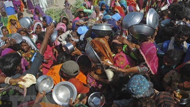 La gente se reúne para recibir ayuda alimentaria en las zonas afectadas por las inundaciones en la provincia de Sindh, Pakistán. (Fotografía: AFP/VNA)
