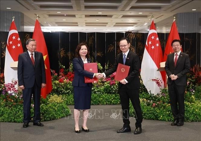 El secretario general del Partido Comunista de Vietnam, To Lam, y el primer ministro de Singapur, Lawrence Wong, presencian el intercambio de la Carta de Intención. (Foto: VNA)