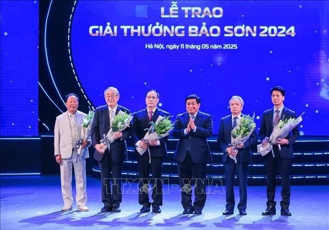 El viceprimer ministro Nguyen Chi Dung entrega flores para felicitar a los ganadores. (Foto: VNA)