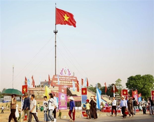 La bandera nacional ondean en la torre de la bandera en el sitio de reliquias históricas nacionales del puente Hien Luong sobre el río Ben Hai (Foto: VNA)