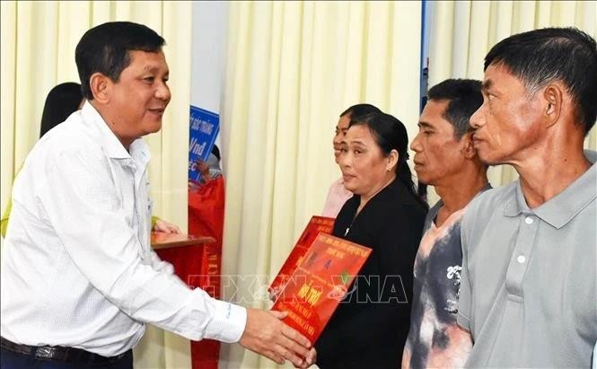 Duong Sa Kha, secretario del Comité partidista del municipio de Vinh Chau, entrega de manera simbólica las nuevas viviendas a familias desfavorecidas. (Foto: VNA)