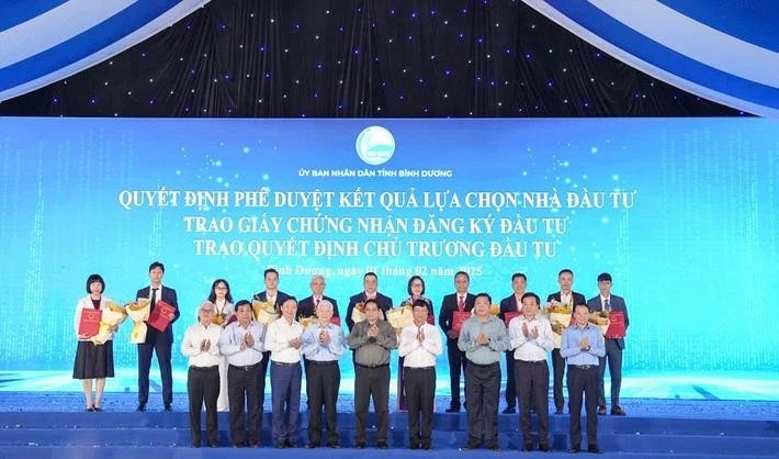 El primer ministro Pham Minh Chinh y los funcionarios del Estado y de la provincia de Binh Duong entregan licencias de registro de inversión a las empresas. (Foto: daibieunhandan.vn)