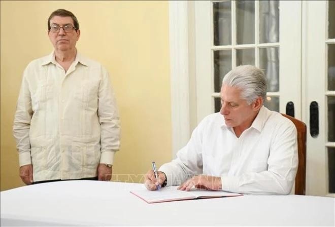 El primer secretario del Comité Central del Partido Comunista y presidente de Cuba, Miguel Díaz-Canel Bermúdez, escribe en el libro de condolencias. (Foto: VNA)