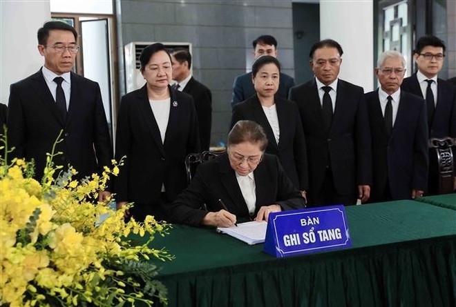 La vicepresidenta de Laos, Pany Yathotou, escribe en el libro de condolencias del expresidente Tran Duc Luong. (Foto: VNA)