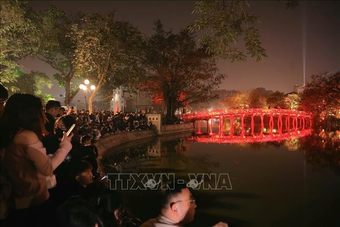 Los hanoyenses esperan dar la bienvenida al Nuevo Año 2025 en los espacios peatonales en el lago Hoan Kiem. (Foto: VNA)