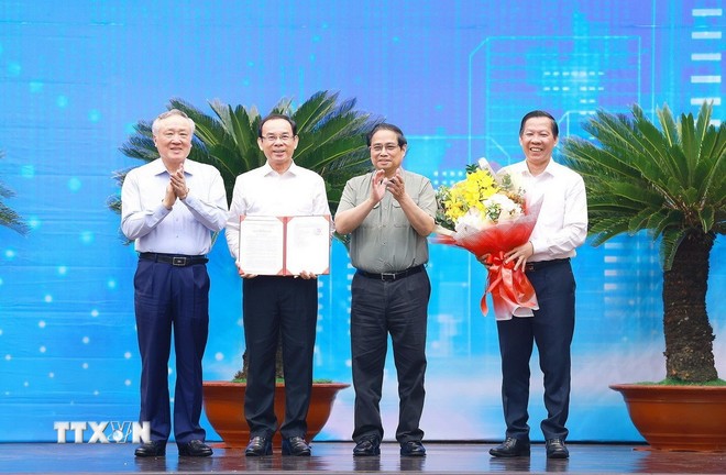 El primer ministro vietnamita, Pham Minh Chinh (segundo desde la derecha), entrega a las autoridades locales la decisión que aprueba la planificación de Ciudad Ho Chi Minh. (Foto: VNA)