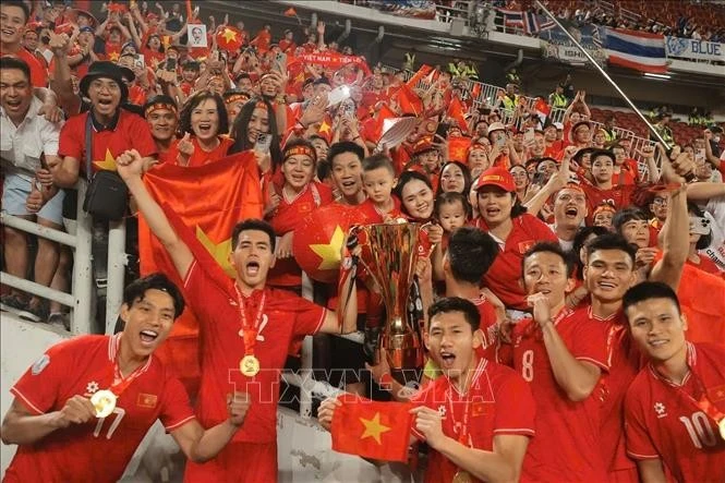 Jugadores de la selección nacional de fútbol celebran el triunfo con los fanáticos. (Foto: VNA)