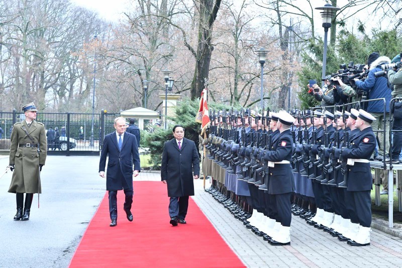 El primer ministro de Polonia, Donald Tusk, y su homólogo vietnamita, Pham Minh Chinh, pasan revista a la guardia de honor. (Foto: VNA)