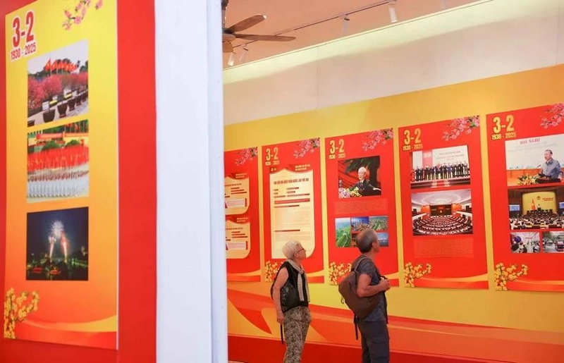 Turistas internacionales visitan una exposición por el aniversario 95 de la fundación del Partido Comunista de Vietnam. (Foto: VNA)