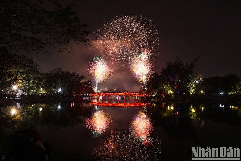 Los fuegos artificiales se lanzan sobre el puente The Huc, en el lago Hoan Kiem.