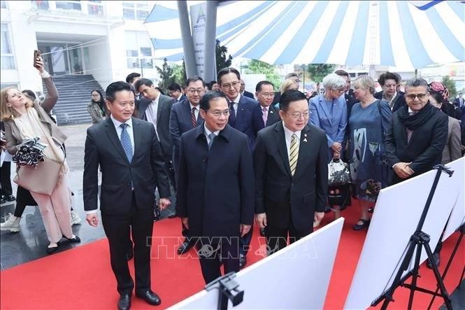 El viceprimer ministro y canciller, Bui Thanh Son (centro, al frente), y los delegados representantes de otros países de la Asean visitan la exposición. (Foto: VNA)