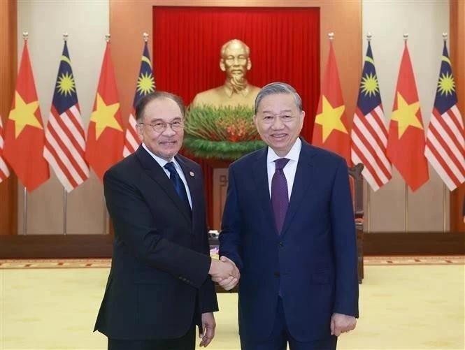 El secretario general del Partido Comunista de Vietnam, To Lam (derecha.), estrecha la mano del primer ministro de Malasia, Anwar Ibrahim. (Foto: VNA)