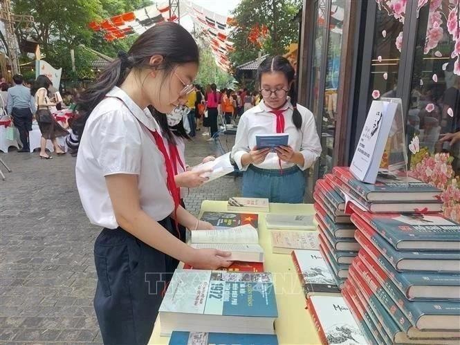 Los estudiantes leen libros en la calle de los libros de Hanói. (Foto: VNA)