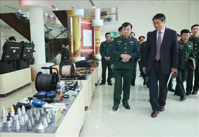 El coronel general Hoang Xuan Chien (izquierda), viceministro de Defensa de Vietnam, y el embajador de Japón en Hanói, Ito Naoki, aprecian los modelos de procesamiento de señales de material explosivo en el VNMAC. (Foto: VNA)