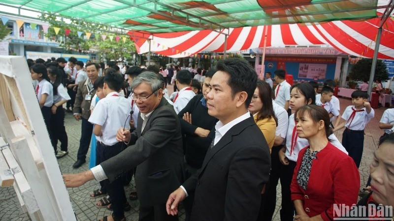 El fotógrafo Ong Van Sinh presenta sus obras a estudiantes y residentes de la comuna de Hoa Bac, distrito de Hoa Vang, ciudad de Da Nang.