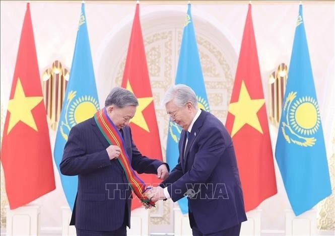 El presidente kazajo, Kassym-Jomart Tokayev (derecha), entrega la Orden de Dostyk de Primera Clase al secretario general del Partido Comunista de Vietnam, To Lam. (Foto: VNA)