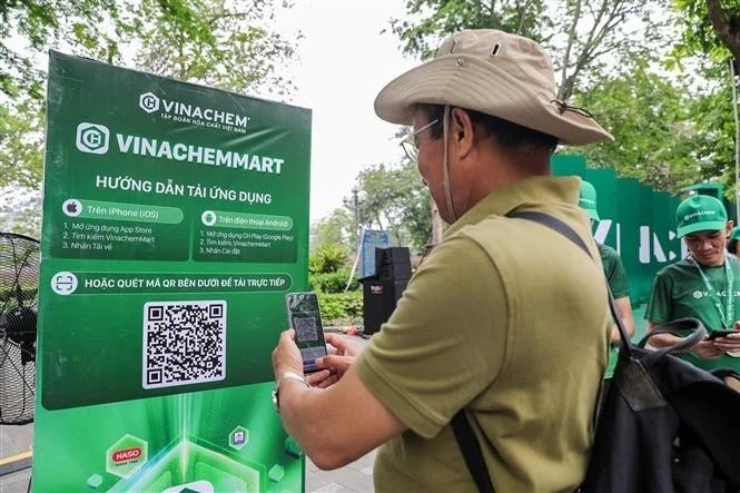 Un hombre escanea el código QR de la plataforma de comercio electrónico VinachemMart. (Foto: VNA)