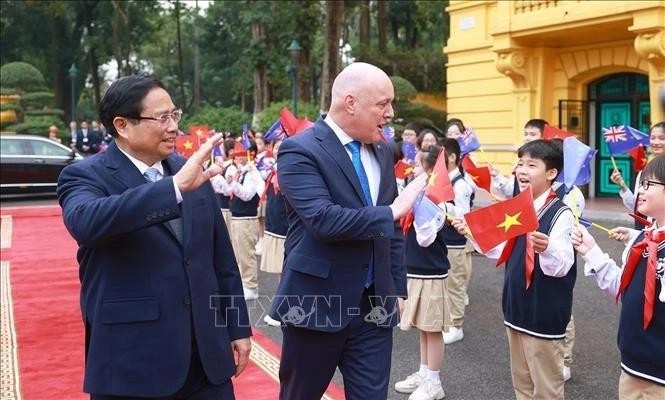 El primer ministro de Vietnam, Pham Minh Chinh, y su homólogo neozelandés, Christopher Luxon, con los estudiantes de Hanói. (Fuente: VNA)