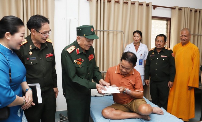 El mayor general Vo Van Chot, ex comandante adjunto de la Región Militar 4 entrega regalo al soldado herido laosiano (Fuente: VNA)