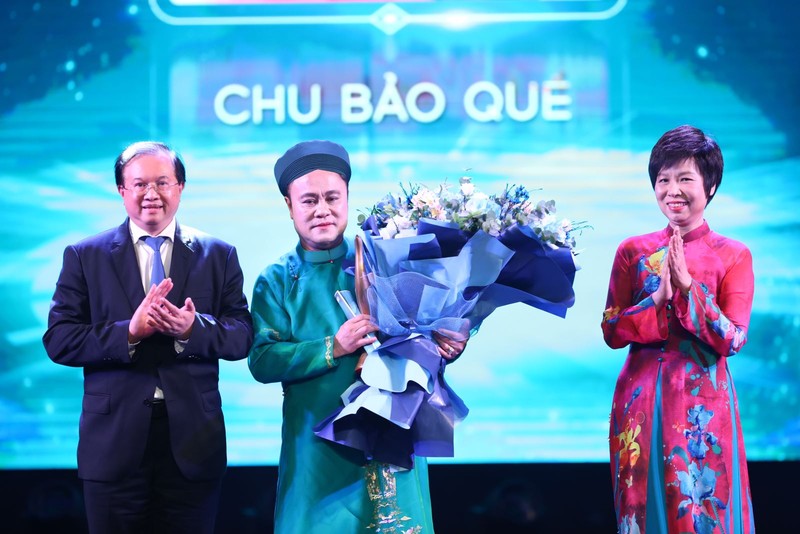 La directora general de la VNA, Vu Viet Trang (derecha), y el viceministro de Cultura, Deportes y Turismo, Ta Quang Dong (izquierda), entregan el premio de Artista inspirador a Chu Bao Que. (Foto: VNA)