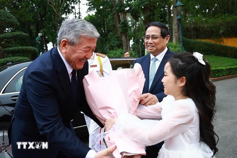 El primer ministro de Kirguistán, Adylbek Kasimalyev, recibe flores en la ceremonia de bienvenida. (Foto: VNA)