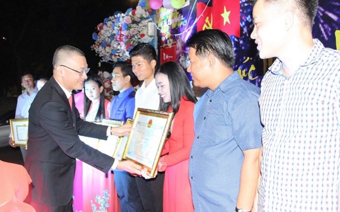 El embajador Vu Quang Minh otorga a los estudiantes sobresalientes certificados de reconocimiento.