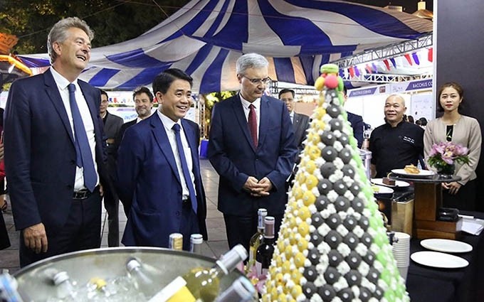 El presidente del Comité Popular de Hanói, Nguyen Duc Chung, y el embajador de Francia en Vietnam, Bertrand Lortholary, visitan un stand en el Festival. (Fotografía: ANTĐ.VN)