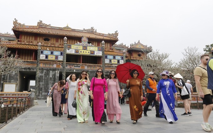 Turistas con Ao Dai en ciudadela imperial de Hue.