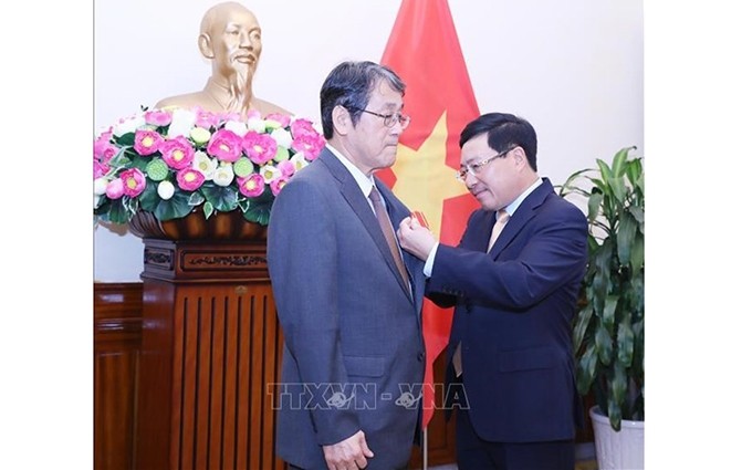 El viceprimer ministro y canciller de Vietnam, Pham Binh Minh, entrega la Orden de Amistad al embajador japonés, Umeda Kunio. (Fotografía: VNA)