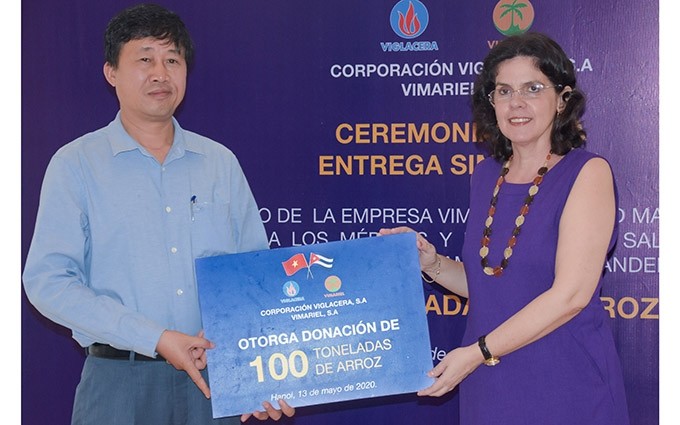 El director general adjunto de Viglacera, Tran Ngoc Anh, entrega el donativo simbólico a la embajadora de Cuba en Vietnam, Lianys Torres. 