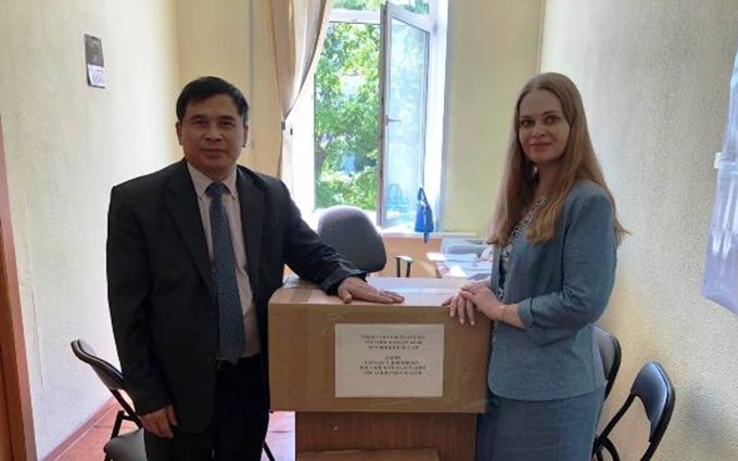 Nguyen Quang Thanh entrega las mascarillas a una representante del gobierno de Uliánovsk. (Fotografía: Nhan Dan)