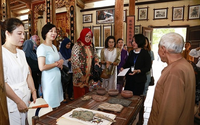 Las delegadas visitan el taller de pintura de Dong Ho del artesano Nguyen Dang Che. (Fotografía: baoquocte.vn) 