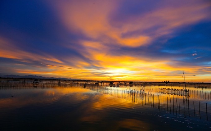 El halo púrpura mezclado con la luz solar imprime a la laguna un aspecto poético y fantasioso. (Fotografía: Nhan Dan/Nam Nguyen)