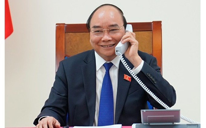 El primer ministro de Vietnam, Nguyen Xuan Phuc, sostiene una conversación telefónica con su homólgo de Tailandia, Prayut Chan-ocha. (Fotografía: VGP)