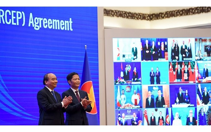 El primer ministro de Vietnam, Nguyen Xuan Phuc, y el titular de Industria y Comercio del país, Tran Tuan Anh, en la firma del RCEP, efectuada el 15 de noviembre. (Fotografía: baoquocte.vn)