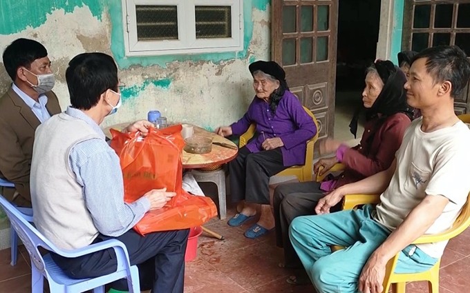Representantes del periódico Nhan Dan entregan regalos a Dong Van Han, inválido de guerra en la comuna de Quang Khe.