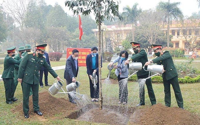 La jefa de la Comisión de Movilización de Masas del Comité Central del PCV, Truong Thi Mai planta árboles en el Regimiento de la capital (división 308).