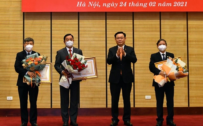 El secretario del Comité del Partido Comunista de Vietnam en Hanói, Vuong Dinh Hue, entrega el título “Médico del Pueblo” a los médicos.